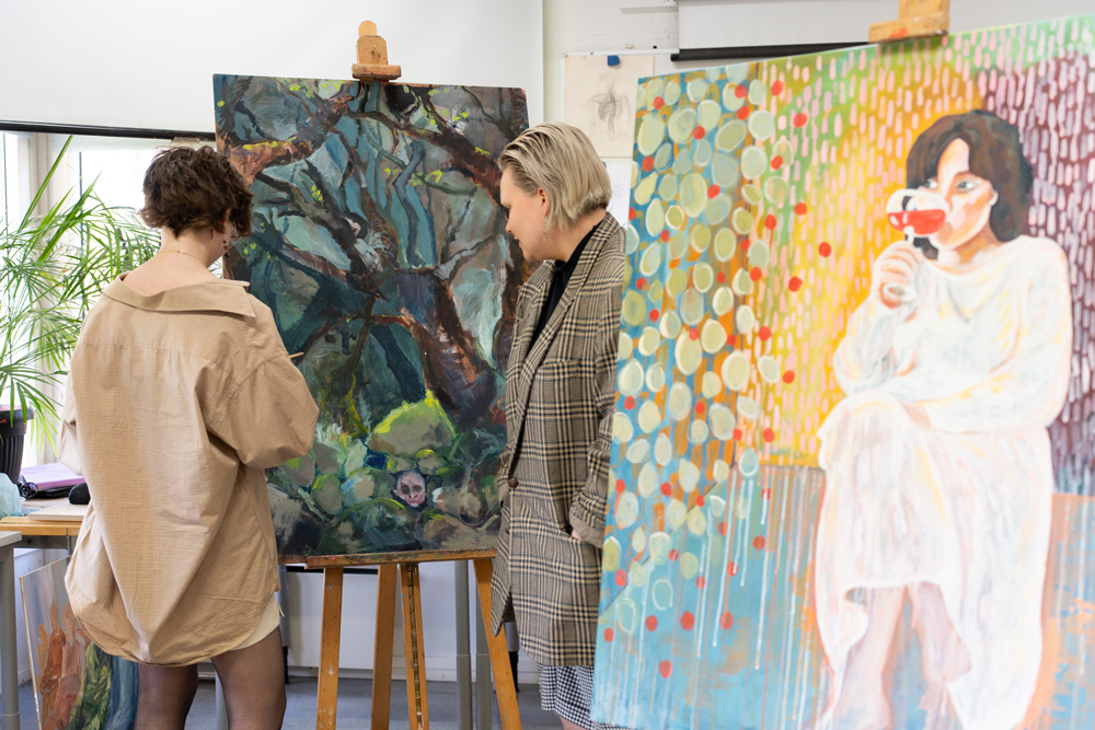 Kuvataiteen opiskelijat katsovat maalausta.
