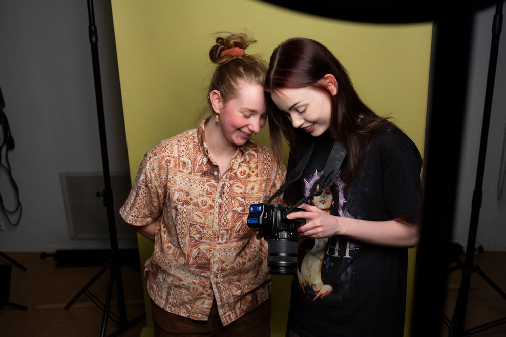 Kansanopistolinjat valokuvaus, opiskelijat katsovat kuvia kamerasta.