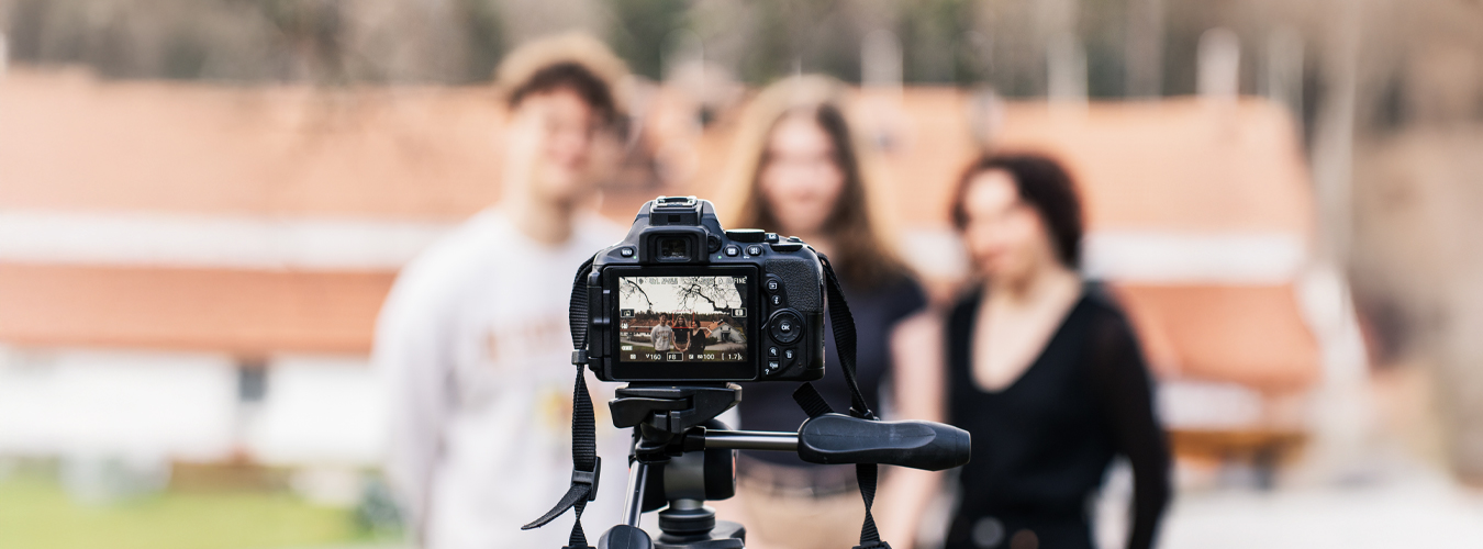 Kansanopistolinjat valokuvaus, kolme henkilöä kameran edessä.